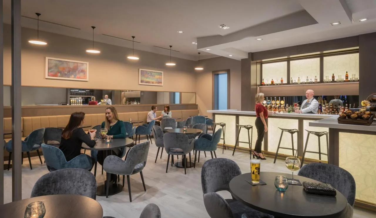 a restaurant with people sitting at tables and a bar at Maldron Hotel Newcastle in Newcastle upon Tyne